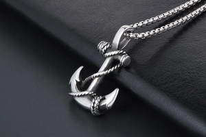 Close-up of vintage anchor pendant with rope detail on stainless steel box chain