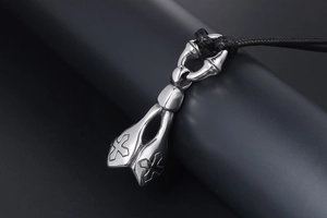 Macro shot of punk gothic stainless steel lotus pendant with double cross engravings