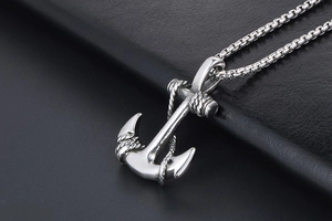 Detail of vintage anchor pendant with rope texture and stainless steel box chain