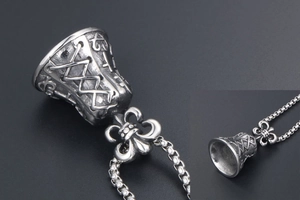 Detailed close-up of retro bell pendant with fleur-de-lis carving and oxidized finish