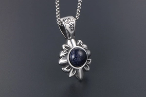 Détail macro du pendentif fleur gothique en grès bleu avec poinçon couronne gravé