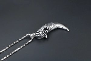 Detailed close-up of retro wolf tooth pendant with intricate animal head carvings