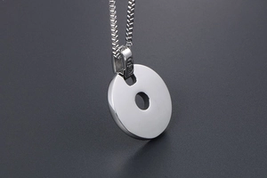 Gros plan du pendentif cercle en argent poli avec chaîne vénitienne sur fond sombre