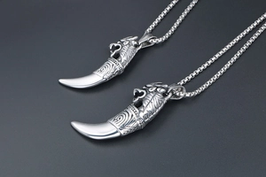 Detailed view of vintage silver wolf fang pendant with intricate wolf head carving on chain