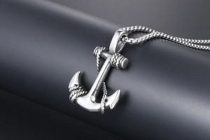 Detailed macro shot of vintage stainless steel anchor pendant with box chain and rope texture