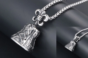 Macro shot of vintage silver bell pendant necklace with fleur-de-lis motif and chain detail