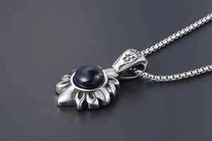 Vue macro du pendentif fleur de lys rétro avec pierre de sable bleu scintillant