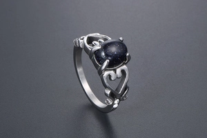 Dettaglio del motivo a cuore e della pietra blu luccicante sull'anello in acciaio titanio