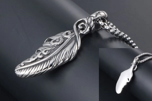 Macro detail of silver feather pendant with fine wing textures and smooth mirror back finish