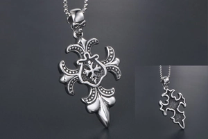 Détail du pendentif croix gothique en argent avec bélière tête de mort et blason