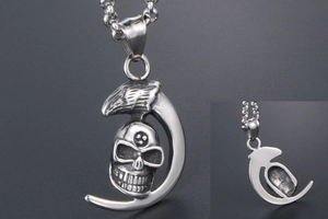 Detailed macro view of silver moon skull pendant with gothic eagle wing carvings