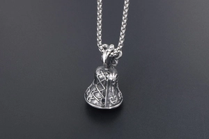 Close-up of vintage silver bell pendant with cross relief and durable box chain