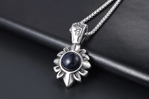 Vue macro d'un pendentif fleur en acier titane avec pierre de grès bleu étincelante