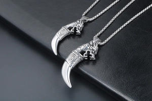 Close-up of vintage wolf fang pendant necklaces with detailed Viking engravings