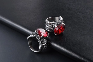 Macro de deux bagues punk vintage avec pierres rouges ovales sur fond de cuir noir