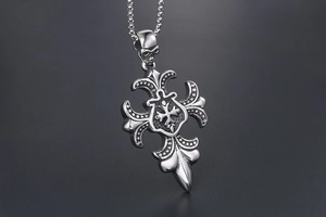 Détail du pendentif croix gothique en argent avec crâne et gravures métalliques
