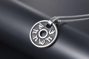 Vue détaillée du pendentif vintage en acier titane avec mantra en relief et fini mat