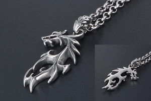 Gros plan du pendentif dragon en acier titane argenté avec détails d'écailles sur chaîne épaisse