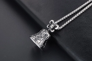 Macro shot of vintage silver bell pendant with cross motif and rustic metal texture