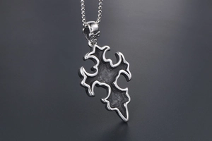 Gros plan d'un pendentif tête de mort gothique avec croix en acier et détails vintage