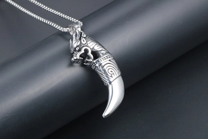 Close-up of vintage wolf fang pendant with detailed dragon head on box chain necklace
