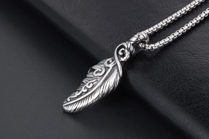 Macro detail of vintage silver feather pendant with intricate oxidized metal textures