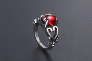 Dettaglio dell'anello a forma di cuore con gemma rossa e zirconi laterali incastonati