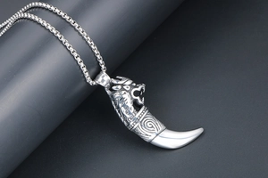 Detail of silver dragon head wolf tooth pendant with vintage punk style metal chain