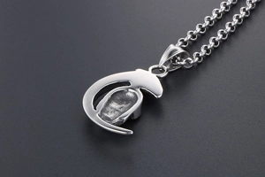 Macro shot of silver crescent moon skull pendant with polished stainless steel chain