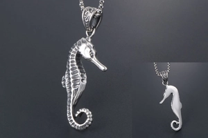 Macro shot of silver seahorse pendant with textured scales and polished mirror back