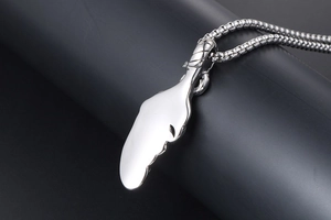 Macro shot of polished silver feather pendant with thick round link chain