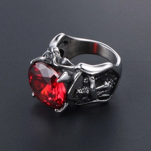 Bague gothique avec rubis rouge imposant et gravures détaillées de crânes en acier vieilli
