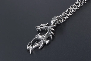 Détail d'un pendentif dragon en acier titane avec chaîne rolo robuste au style punk