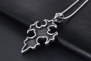 Détail macro du pendentif croix gothique avec détails de crâne et acier inoxydable poli