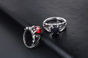 Dettaglio anelli vintage a cuore con gemme di granato rosso e pietra blu notte