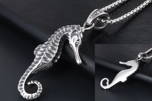 Detailed close-up of a vintage seahorse pendant in steel showing both front and back sides