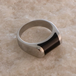Gros plan d'une bague en acier inoxydable argenté avec un insert rectangulaire en résine noire