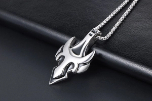 Detailed shot of silver wolf fang titanium steel pendant with black engraved accents