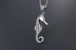 Close-up of vintage seahorse pendant featuring detailed scale textures and steel chain