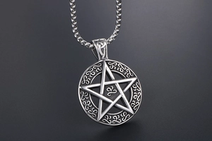 Macro shot of vintage titanium steel pentagram pendant with Celtic knot engravings