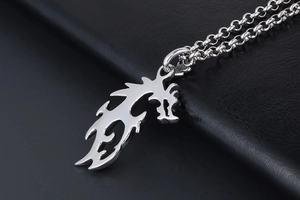 Vue macro d'un pendentif dragon en acier inoxydable poli sur une surface en cuir