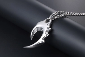 Détail macro du pendentif griffe en acier inoxydable argenté aux bords dentelés