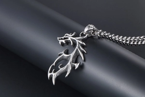 Vue macro d'un pendentif dragon en acier inoxydable poli aux détails gothiques