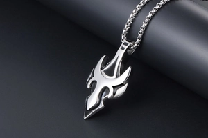 Macro side view of silver tribal tooth pendant with square box chain on leather background