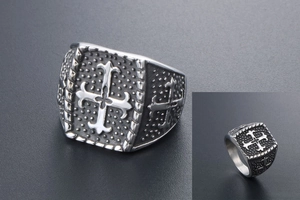 Nahaufnahme des Vintage-Siegelrings mit Kreuzrelief und verzierter Edelstahloberfläche