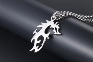 Détail macro d'un pendentif dragon en acier inoxydable avec des motifs ajourés