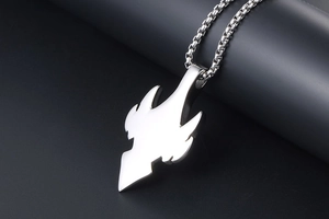 Macro shot of silver stainless steel tribal wing pendant with polished mirror finish