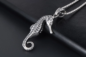 Detailed macro view of silver seahorse pendant with realistic texture on black leather