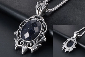 Detail of vintage teardrop pendant with blue sandstone and ornate gothic metal frame