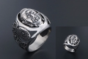 Détail d'une bague vintage en acier inoxydable avec visage de Bouddha et fleurs